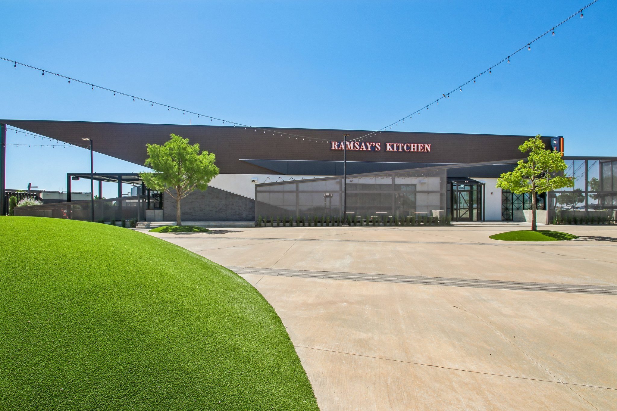 A building with a green lawn in front and a sign that says "Ramsay's Kitchen".